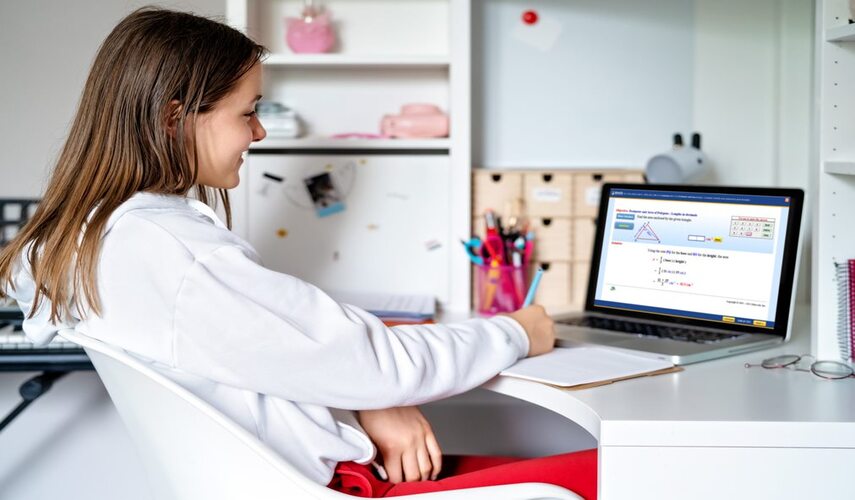 A girl student in a white jacket is learning math using a Laptop displaying the Educo Learning Center Math Course