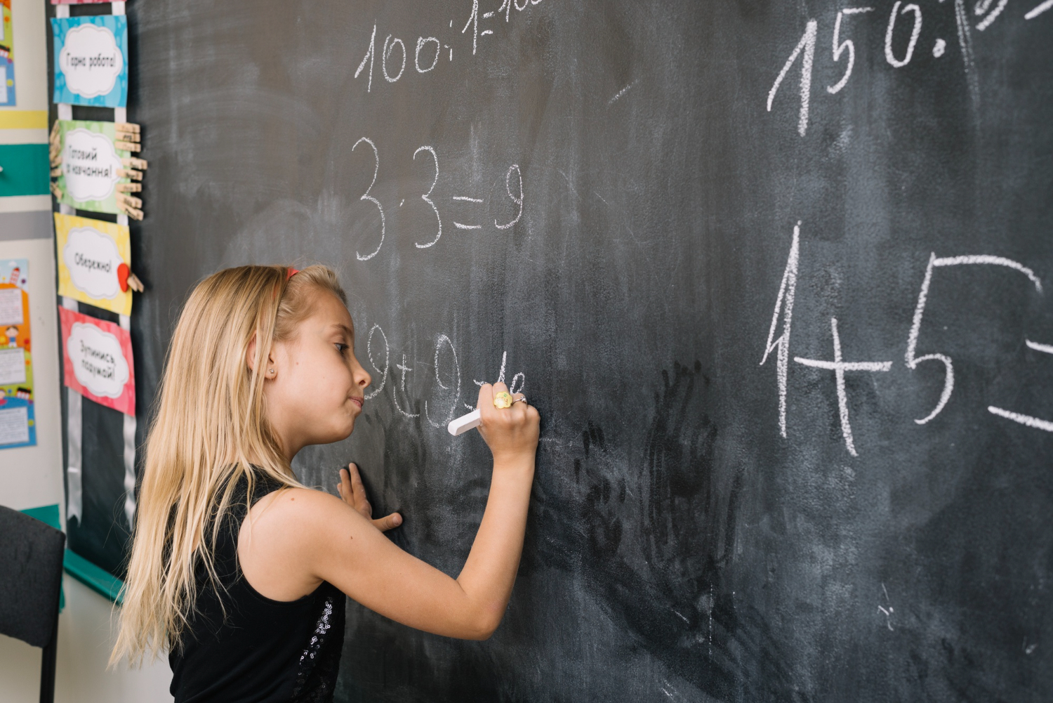 Young girl practising common core math on a class board